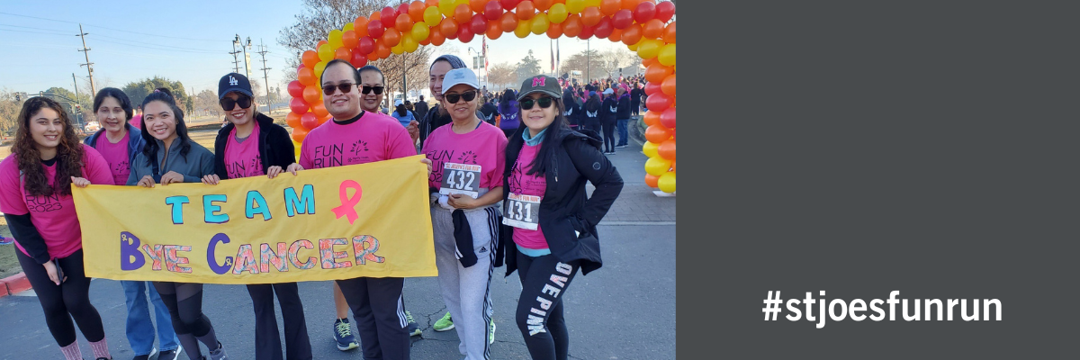 Race participants with sign saying "Team Bye Cancer" #stjoesfunrun